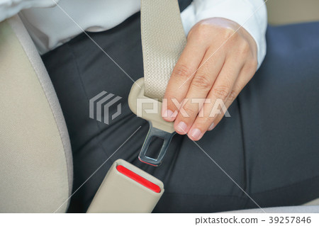 Businesswoman fastening seat belt in car 39257846