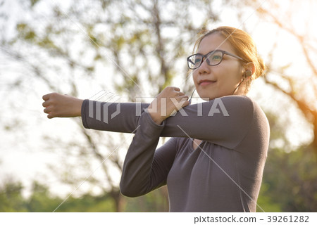 Asian female in grey sportswear workout at the park. 39261282