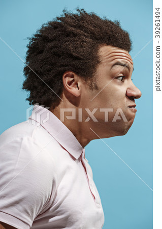 The young emotional angry man screaming on blue The young emotional angry man screaming on blue 39261494
