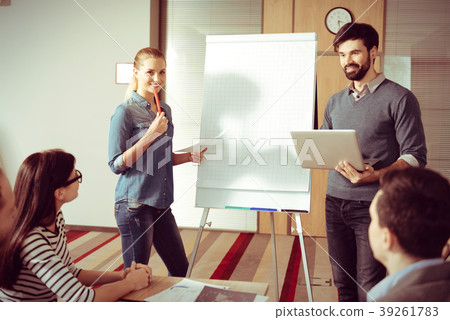 Smart young colleagues standing near the flipchart 39261783
