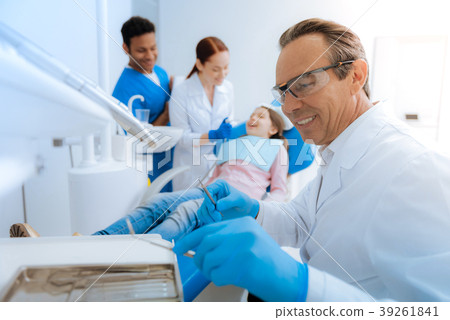 Nice pleasant man holding his instruments Nice pleasant man holding his instruments 39261841