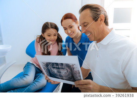 Positive nice doctor showing an X ray photo to his Positive nice doctor showing an X ray photo to his 39261938