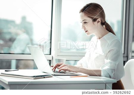 Concentrated busy woman sitting and using the Concentrated busy woman sitting and using the 39262692