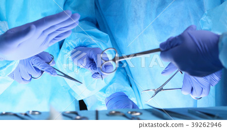 Surgeons hands holding surgical scissors and Surgeons hands holding surgical scissors and 39262946