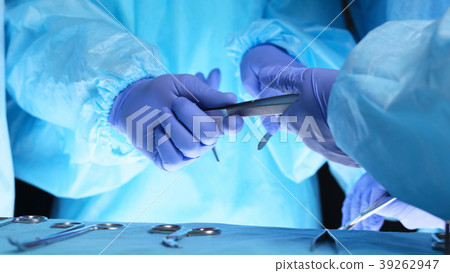 Surgeons hands holding surgical scissors and Surgeons hands holding surgical scissors and 39262947