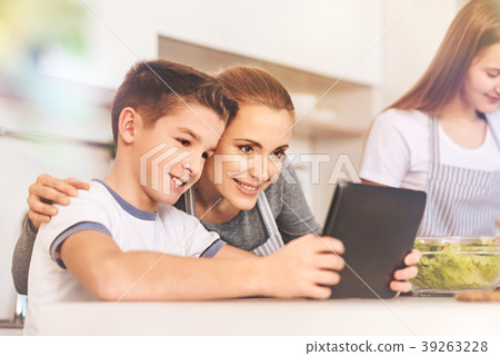 Positive delighted boy taking photo with mother Positive delighted boy taking photo with mother 39263228