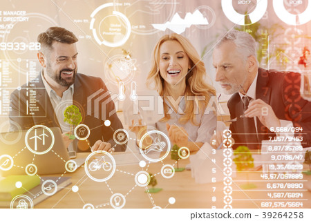 Cheerful coworkers laughing while working at their Cheerful coworkers laughing while working at their 39264258