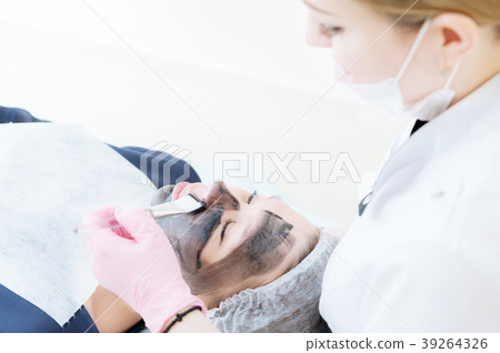 The cosmetologist in pink gloves with a brush 39264326
