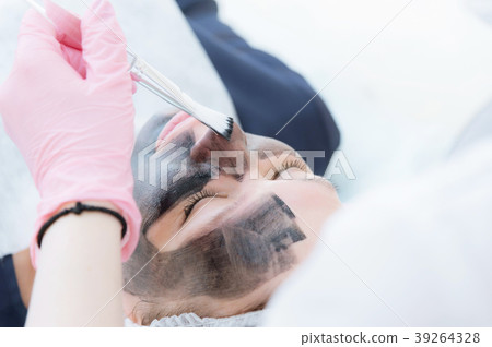 The cosmetologist in pink gloves with a brush 39264328