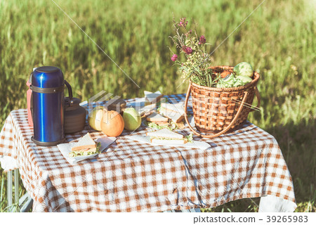 Tasty food for picnic on desk in meadow Tasty food for picnic on desk in meadow 39265983