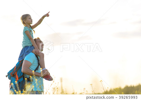 Cheerful man playing with daughter on grassland 39265993