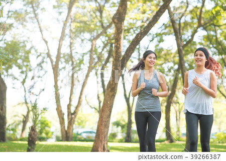 Young Asian woman friends running in the park Young Asian woman friends running in the park 39266387