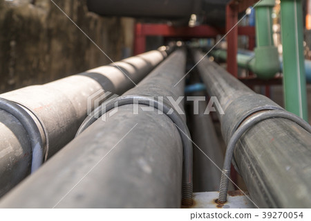 Black long steel pipe next to the concrete wall. 39270054