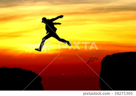 Silhouette of a man jumping over the cliff 39271305