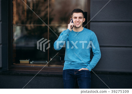 Handsome man is using the phone on the street Handsome man is using the phone on the street 39275109