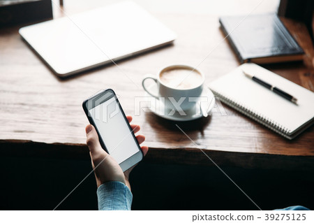Man using phone inside a restaurant while drinking 39275125