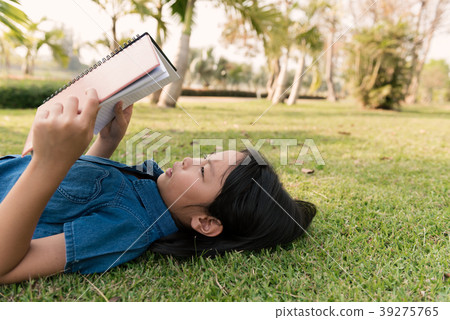 The girl is serious reading in meadow 39275765