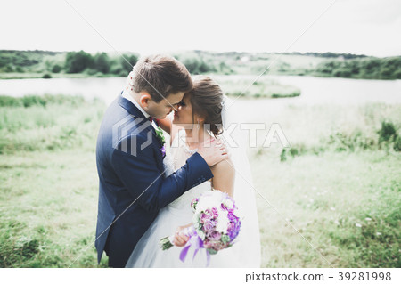 Newly married couple running and jumping in park 39281998