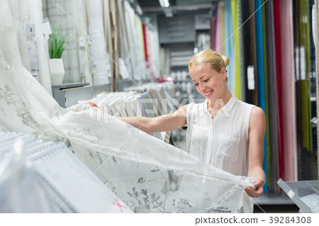Beautiful housewife buying white curtains in home 39284308