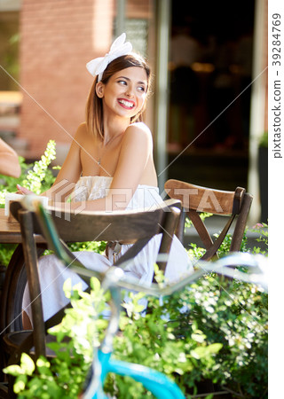 Smiling female sitting in a cosy cafe on a sunny day Smiling female sitting in a cosy cafe on a sunny day 39284769