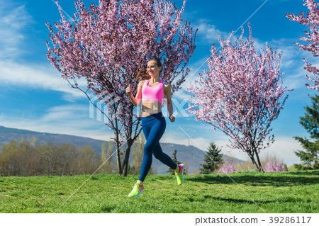Woman doing sport running on hill between Woman doing sport running on hill between 39286117