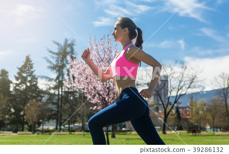 Woman running fast for sport on sunny day Woman running fast for sport on sunny day 39286132