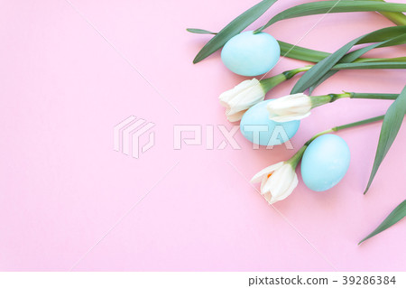 Easter eggs and spring flowers narcissi on pink ba 39286384