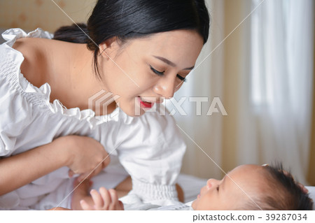 Newborn Concept. Mother and child on a white bed. Mom and baby b Newborn Concept. Mother and child on a white bed. Mom and baby b 39287034