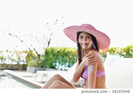 Swimsuit Concept. Beautiful girl in swimsuit is applying sunscre 39287048