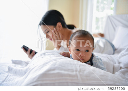 Newborn Concept. Mother and child on a white bed. Mom and baby b Newborn Concept. Mother and child on a white bed. Mom and baby b 39287200