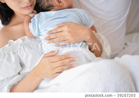 Newborn Concept. Mother and child on a white bed. Mom and baby b 39287203