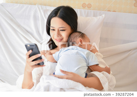 Newborn Concept. Mother and child on a white bed. Mom and baby b 39287204