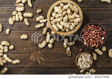 raw peanuts in a plate on a wooden background raw peanuts in a plate on a wooden background 39287946