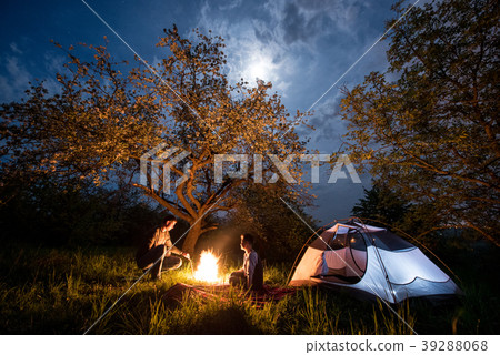 Tourists at campfire near tent. Night camping 39288068