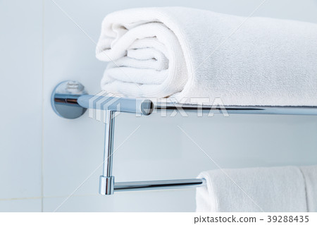 Close up of folded white bathroom towels on rack 39288435