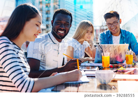 Joyful afro-american working with his colleagues Joyful afro-american working with his colleagues 39288555