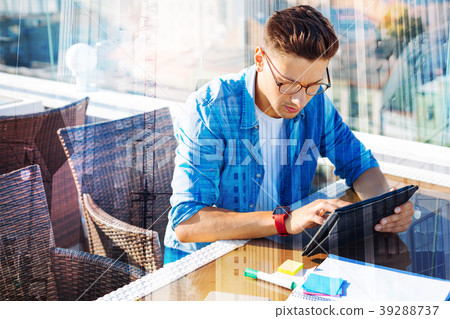 Serious man working on his tablet Serious man working on his tablet 39288737