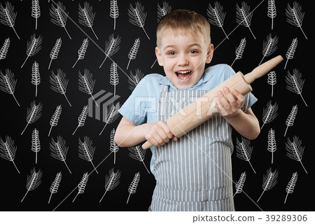 Excited child holding a rolling pin and looking 39289306