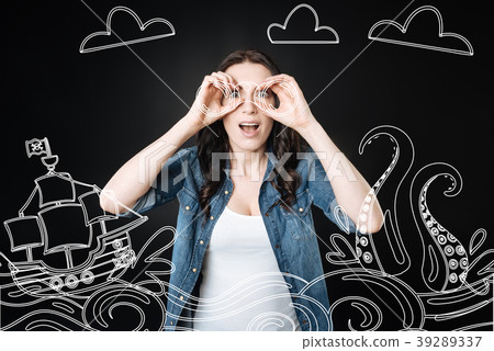 Emotional woman holding a binocular and looking at Emotional woman holding a binocular and looking at 39289337