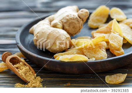 Ginger root and candied ginger on a wooden plate. Ginger root and candied ginger on a wooden plate. 39291385