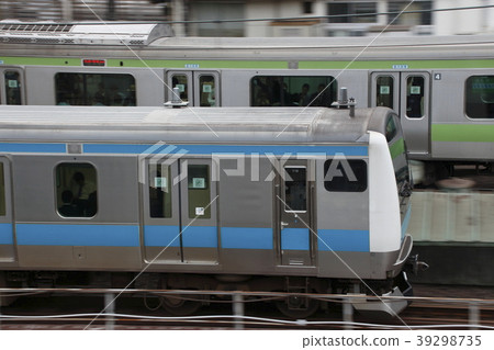 The Yamanote Line E231 Series train and the Keihin-Tohoku Line E233 Series train run parallel to each other. 39298735