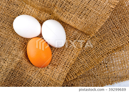 Chicken eggs on sackcloth tablecloth. Chicken eggs on sackcloth tablecloth. 39299689
