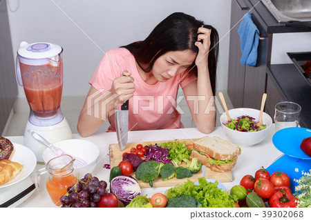 depressed woman cooking with knife in kitchen room 39302068