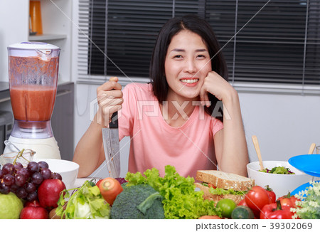 happy woman cooking with knife in kitchen room happy woman cooking with knife in kitchen room 39302069
