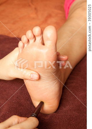 reflexology foot massage by wood stick 39305025