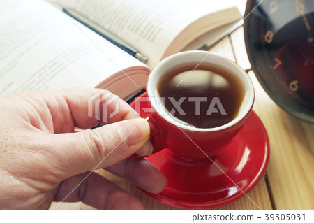 Hand hold red coffee cup with background book  39305031