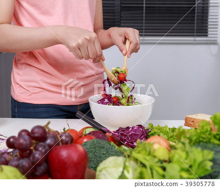 close up woman mixing salad while cooking close up woman mixing salad while cooking 39305778