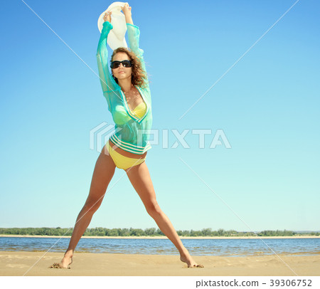 Tanned woman posing at the beach on summer day Tanned woman posing at the beach on summer day 39306752