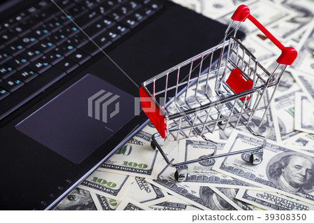 Shopping trolley, laptop and dollars Shopping trolley, laptop and dollars 39308350