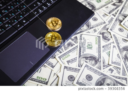 Bitcoins and dollars on a laptop Bitcoins and dollars on a laptop 39308356